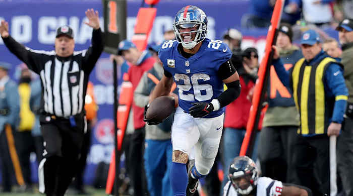 Nov 13, 2022; East Rutherford, New Jersey, USA; New York Giants running back Saquon Barkley (26) reacts after running the ball against Houston Texans linebacker Christian Kirksey (58) during the fourth quarter at MetLife Stadium.